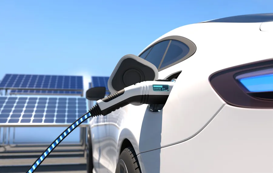 Elektroauto lädt vor einer Photovoltaikanlage